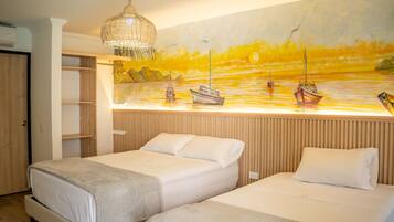 Una camera da letto con due letti, una testiera in legno, un quadro raffigurante un tramonto sull'acqua e una lampada a sospensione.