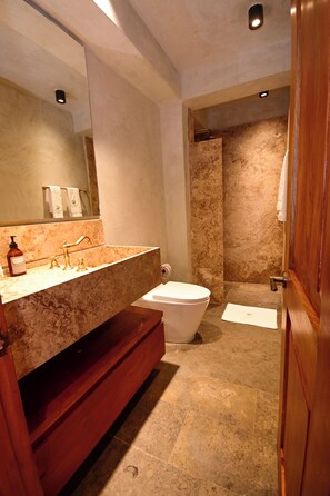 Une salle de bain moderne avec un meuble-lavabo en marbre, des toilettes et un espace douche.