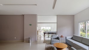 Un moderno vestíbulo de hotel con un sofá, sillas, una mesa de centro y un cubo de basura.