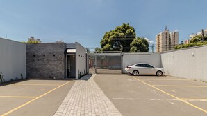 Un espace de stationnement doté d’un chemin pavé menant à une entrée fermée par un portail.