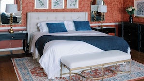 A bedroom with a large bed, two bedside tables, a bench, and a patterned rug. - Bohemia Manor Farm (Chesapeake City)