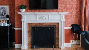 A living room with a fireplace, a television mounted above it, and a sofa. - Bohemia Manor Farm (Chesapeake City)