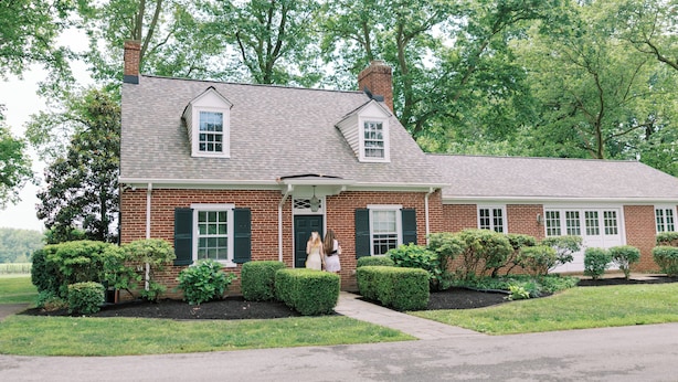 A brick house with a front porch, a chimney, and a well-maintained lawn. - Bohemia Manor Farm (Chesapeake City)