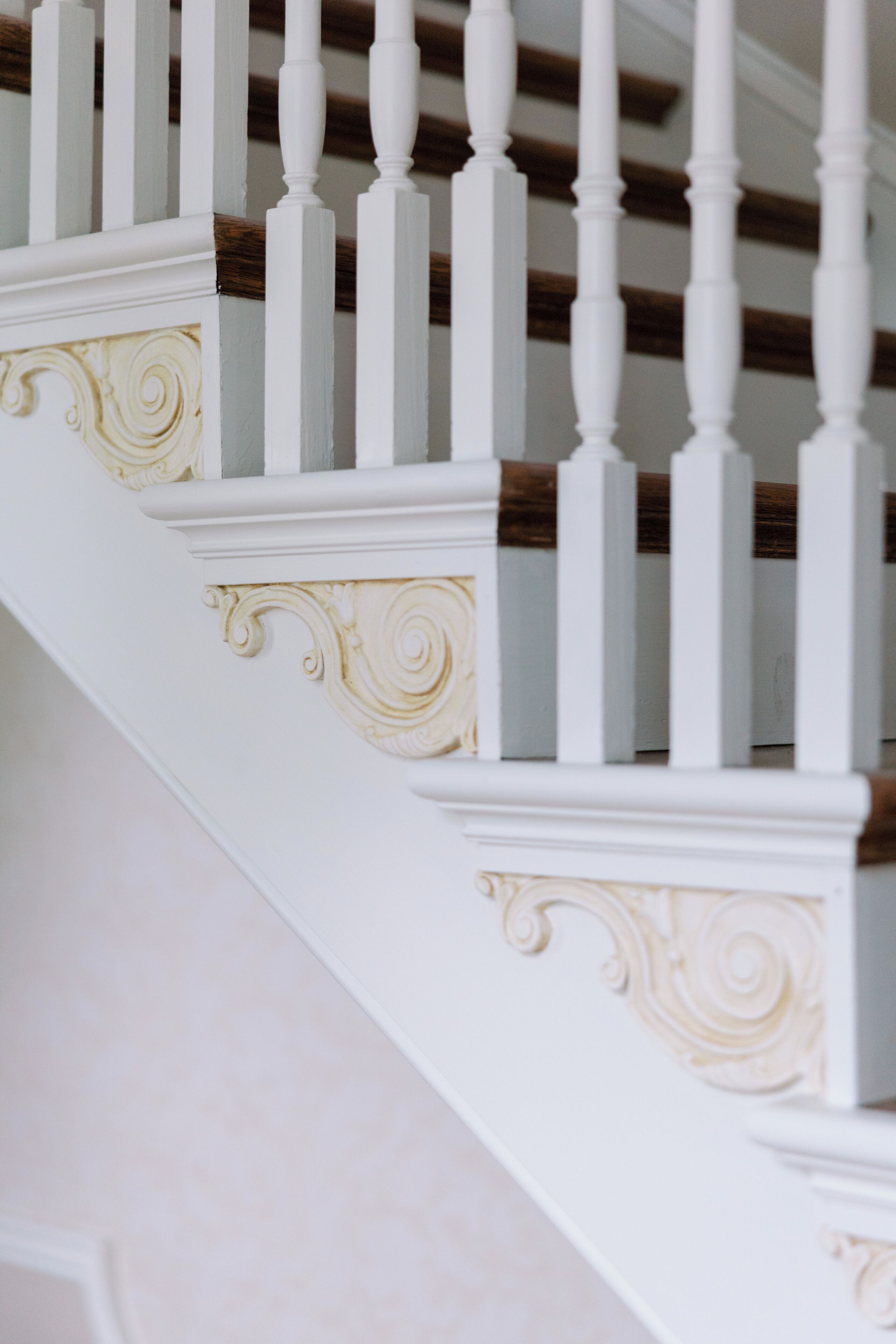 A staircase with white balusters and a wooden handrail.