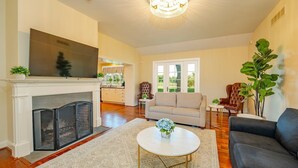 Una sala de estar con chimenea, sofá, mesa de centro y televisor.