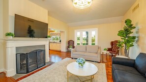 A living room with a fireplace, sofa, coffee table, and a TV. - Bohemia Manor Farm (Chesapeake City)