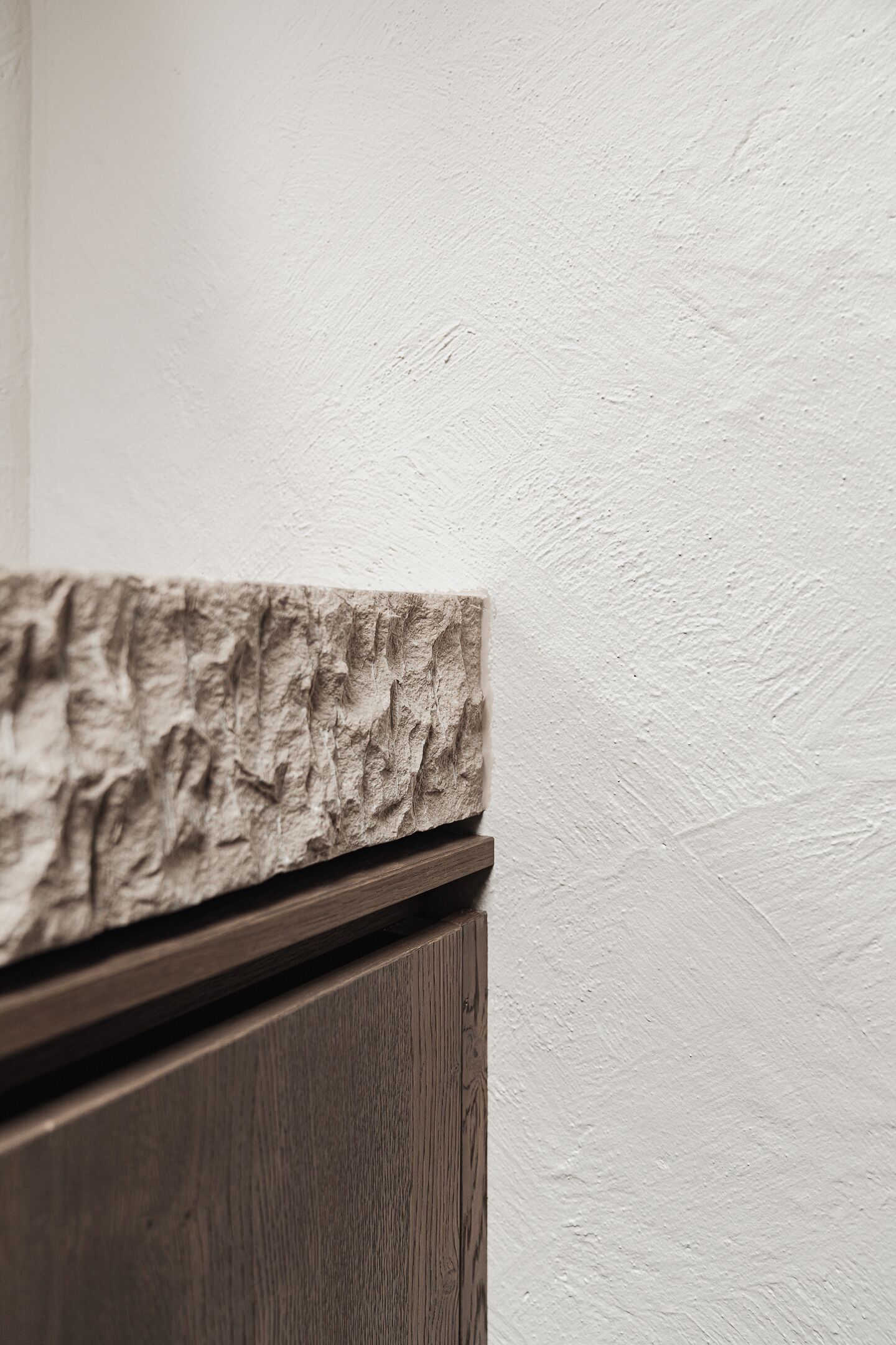 A wooden cabinet with a textured stone-like top.