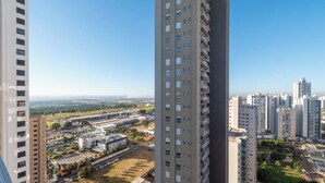 Rascacielos con varios pisos, cielo despejado y una vista distante del paisaje urbano.