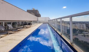 A rooftop pool with a city view, lounge chairs, and a clear sky. - Apartments in Jardim Goias Goiania/go - THO (Goiânia)