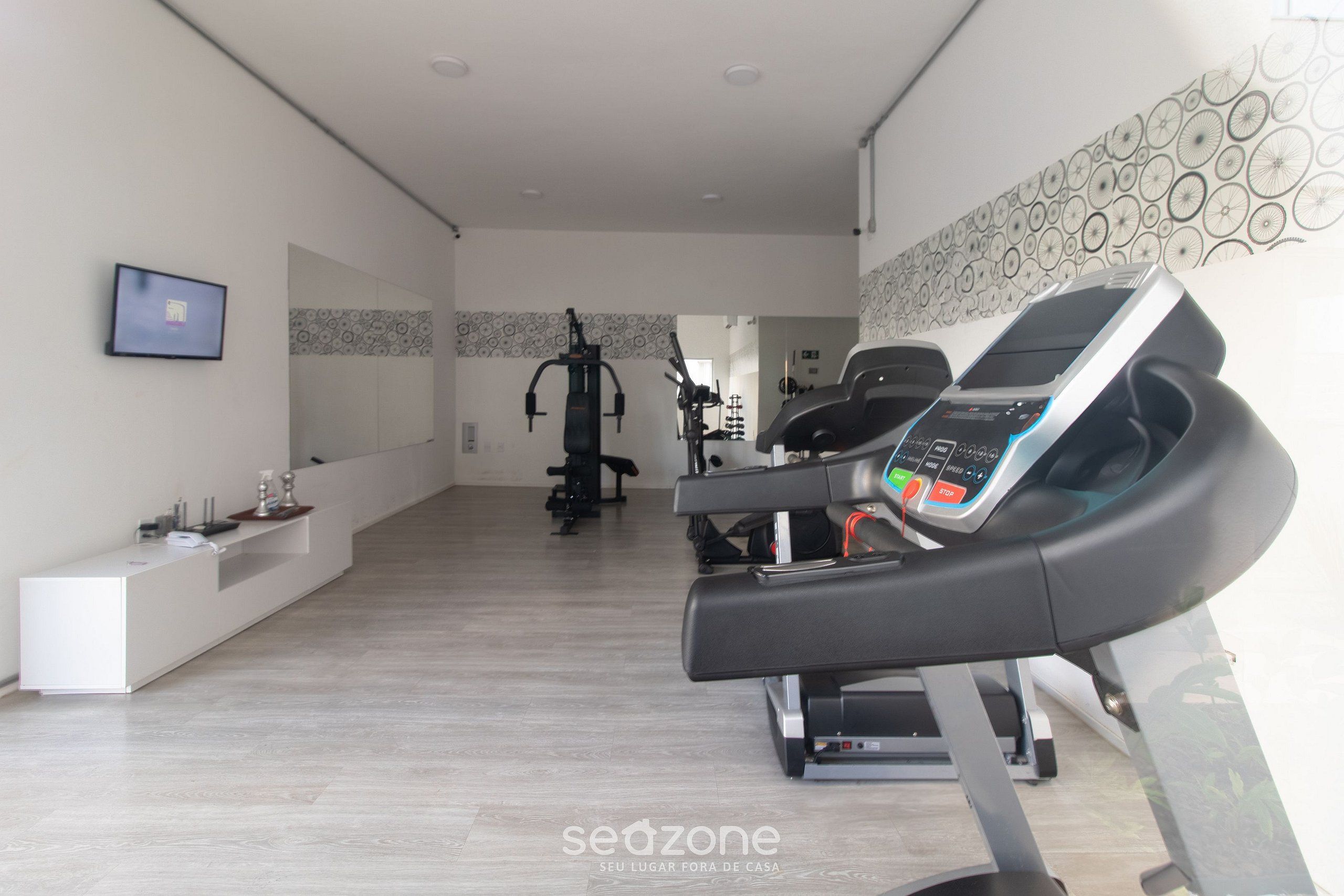 A modern gym with treadmills, a stationary bike, and a weight machine.