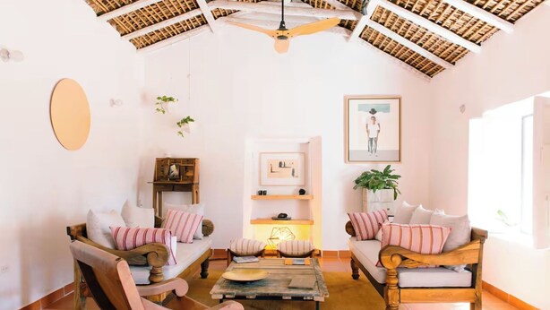 Un salon confortable avec deux canapés, une table basse et un ventilateur de plafond.