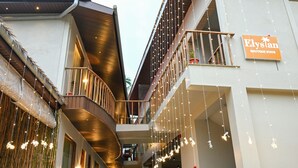 A modern building with a sign reading "Elysian Boutique Stays". - The Elysian Boutique Stays (Port Blair)