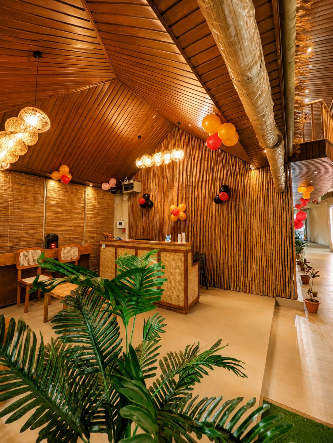 A reception area with a wooden reception desk, wicker chairs, and a bamboo wall.