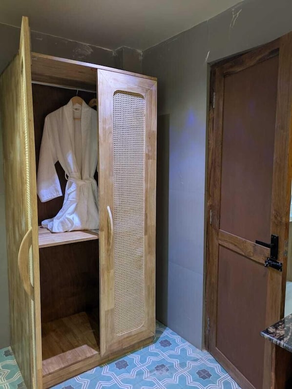 Un armario de madera con una percha, una puerta con un cierre y un suelo estampado.