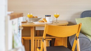 Una mesa de desayuno con un bol de cruasanes, dos vasos de jugo de naranja y una taza de café.