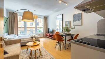 A modern apartment with a living area, dining space, and kitchenette.