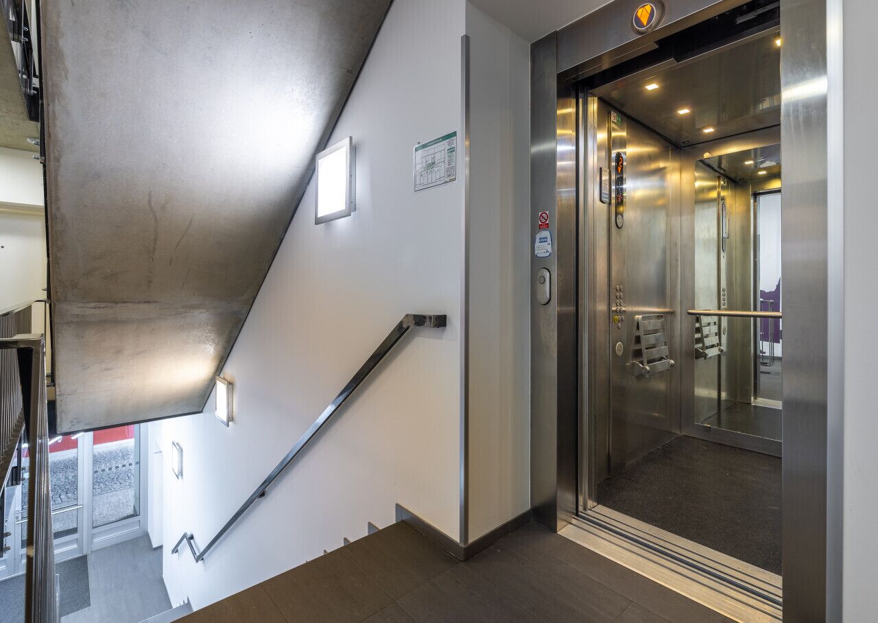 A modern elevator with stainless steel doors and a control panel.