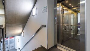 A modern elevator with stainless steel doors and a control panel. - Designer Prague Studio in a Vibrant Neighborhood by EasyBNB Premium (Prague)