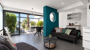 Una sala de estar moderna con un sofá, un comedor y una cocina.