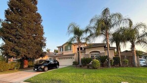 A two-story house with a garage, a driveway, and a well-maintained lawn. - 4-bedroom pool house in Fresno, hub for all California destinations &attractions (Fresno)