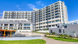 A modern multi-story hotel with a central courtyard, outdoor seating area, and a pool. - Funchal Acqua Blue 3O, a Home in Madeira (Funchal)