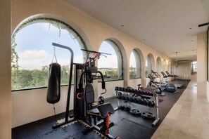 Un gimnasio con equipo de ejercicio, un saco de boxeo y mancuernas.
