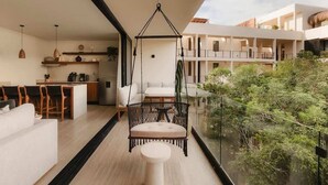 Um interior moderno com uma cadeira suspensa, uma área de refeições e vista para vegetação.