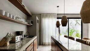 A modern kitchen with a central island, wooden cabinets, and a built-in microwave.