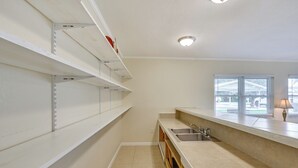 A kitchen with white cabinets, a sink, and a window with blinds. - Home 3 Mi to Homosassa Springs Wildlife State Park (Homosassa)