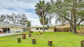 A residential property with a well-maintained lawn, several trees, and a house with a garage and attached garage. - Home 3 Mi to Homosassa Springs Wildlife State Park (Homosassa)