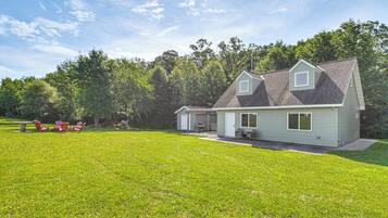 A two-story house with a covered patio and a lawn.