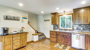 A kitchen with wooden cabinets, a stainless steel refrigerator, and a coffee maker on the counter.