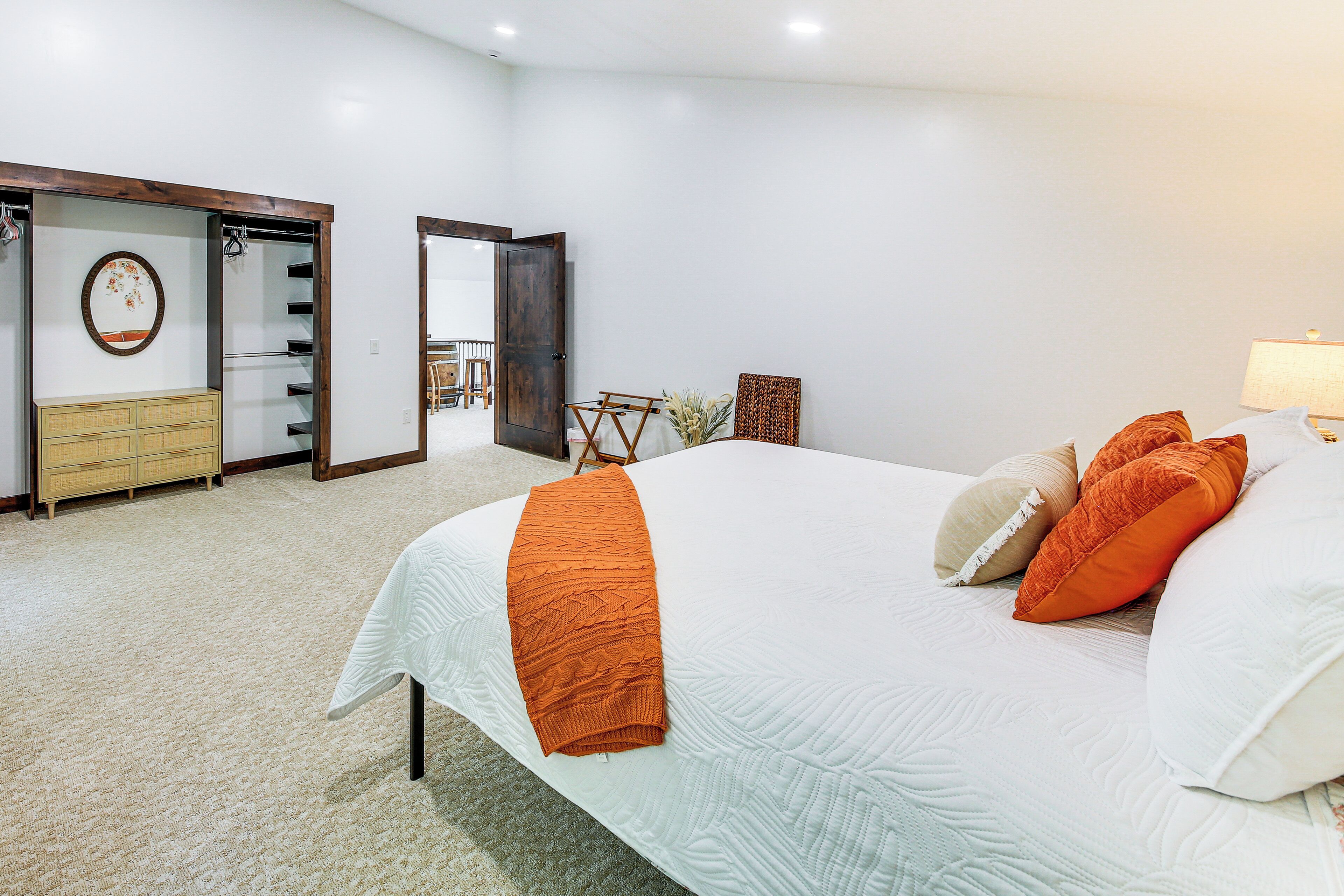 Une chambre à coucher comprenant un lit, une commode, une chaise et une porte donnant sur un balcon.