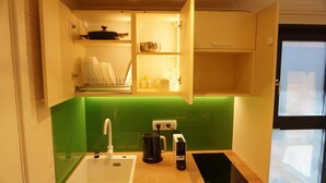 A compact kitchen with a sink, a coffee maker, and a toaster.