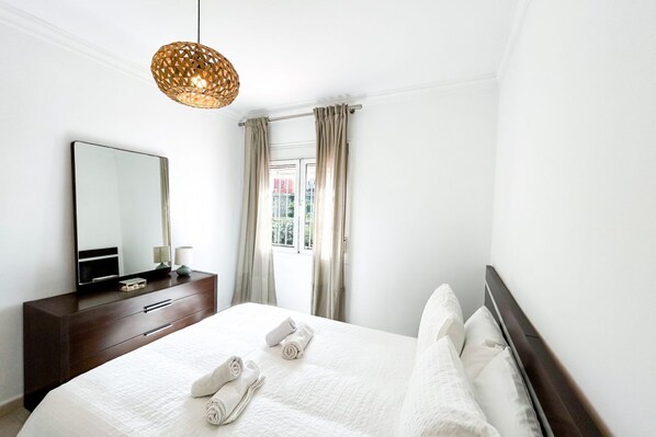 A hotel room with a large bed, a dresser, a mirror, and a window with curtains. - Semi-detached house in second line beach in Manilva (Manilva)