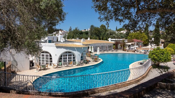 A swimming pool with a white building in the background.