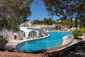 Una piscina con un edificio blanco al fondo.