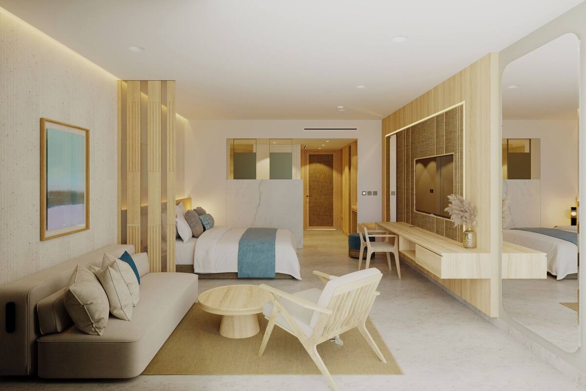 A modern hotel room with a sofa, a bed, a desk, and a large mirror.