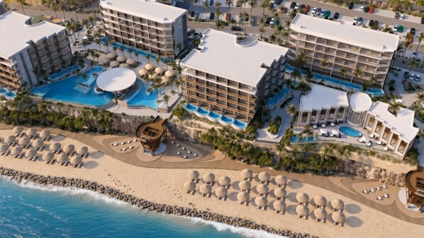 A resort with multiple buildings, a large swimming pool, and a beach area with sun loungers. - TUI BLUE Curacao All Inclusive (Soto)