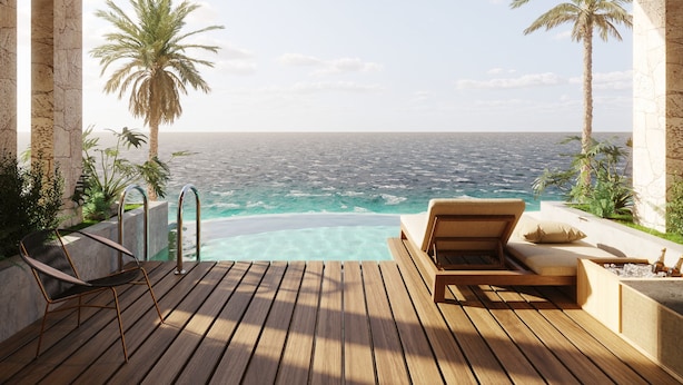 A wooden deck with a pool, lounge chairs, and a view of the ocean. - TUI BLUE Curacao All Inclusive (Soto)