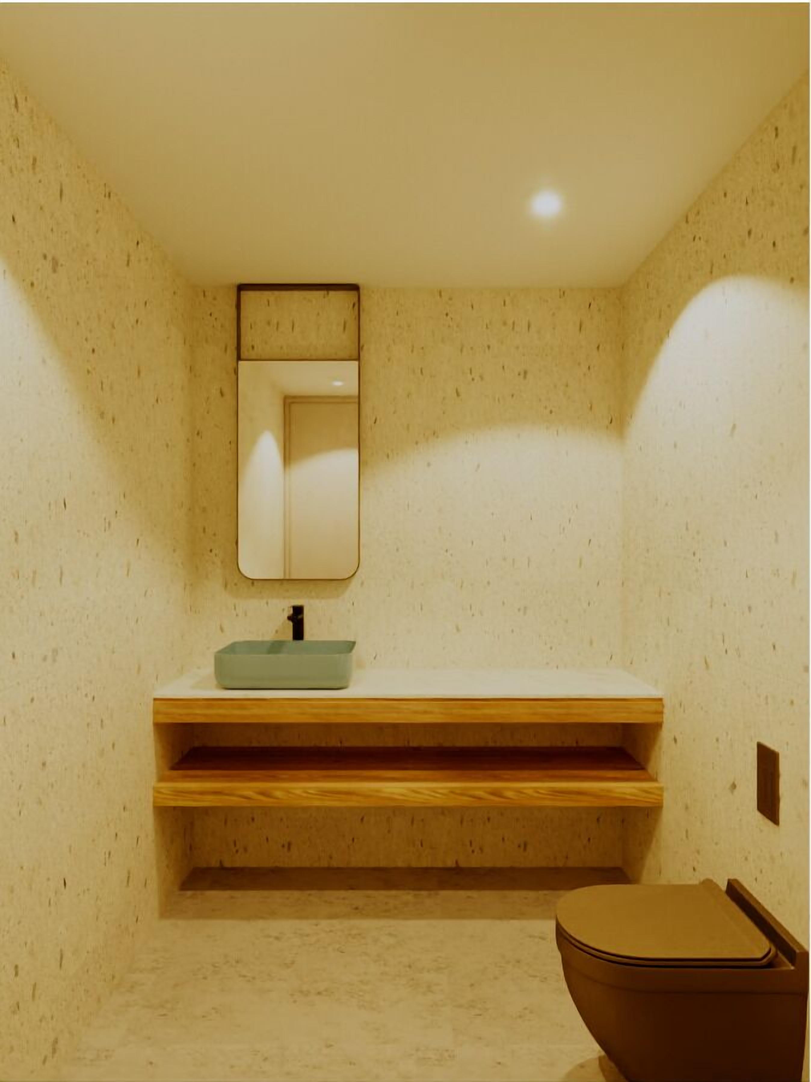 Un baño con tocador de madera, lavamanos y retrete.