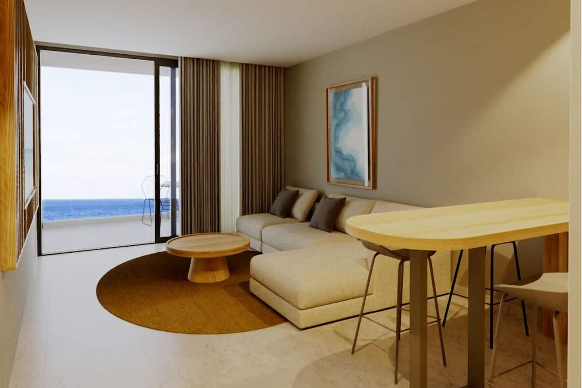 A modern living room with a large window, a round coffee table, a sofa, and a dining table.