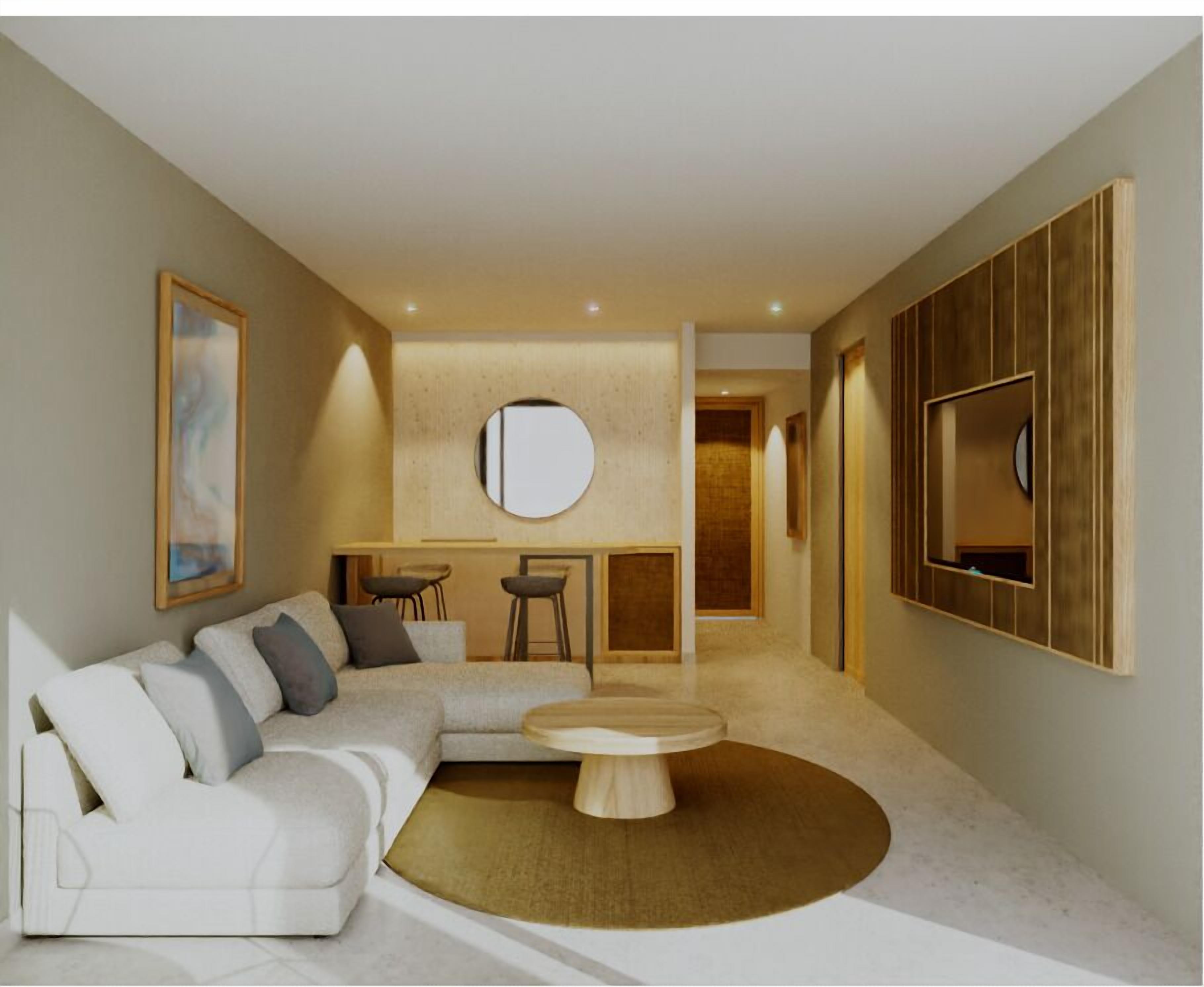 A modern living room with a sectional sofa, a round coffee table, and a TV mounted on the wall.