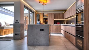 Una cocina moderna con armarios de madera, electrodomésticos integrados y una isla central.