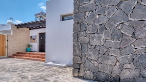 A modern building with a stone facade, a wooden door, and a small window.