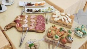 Una mesa de bufé con diversos alimentos, como carnes, quesos y verduras.