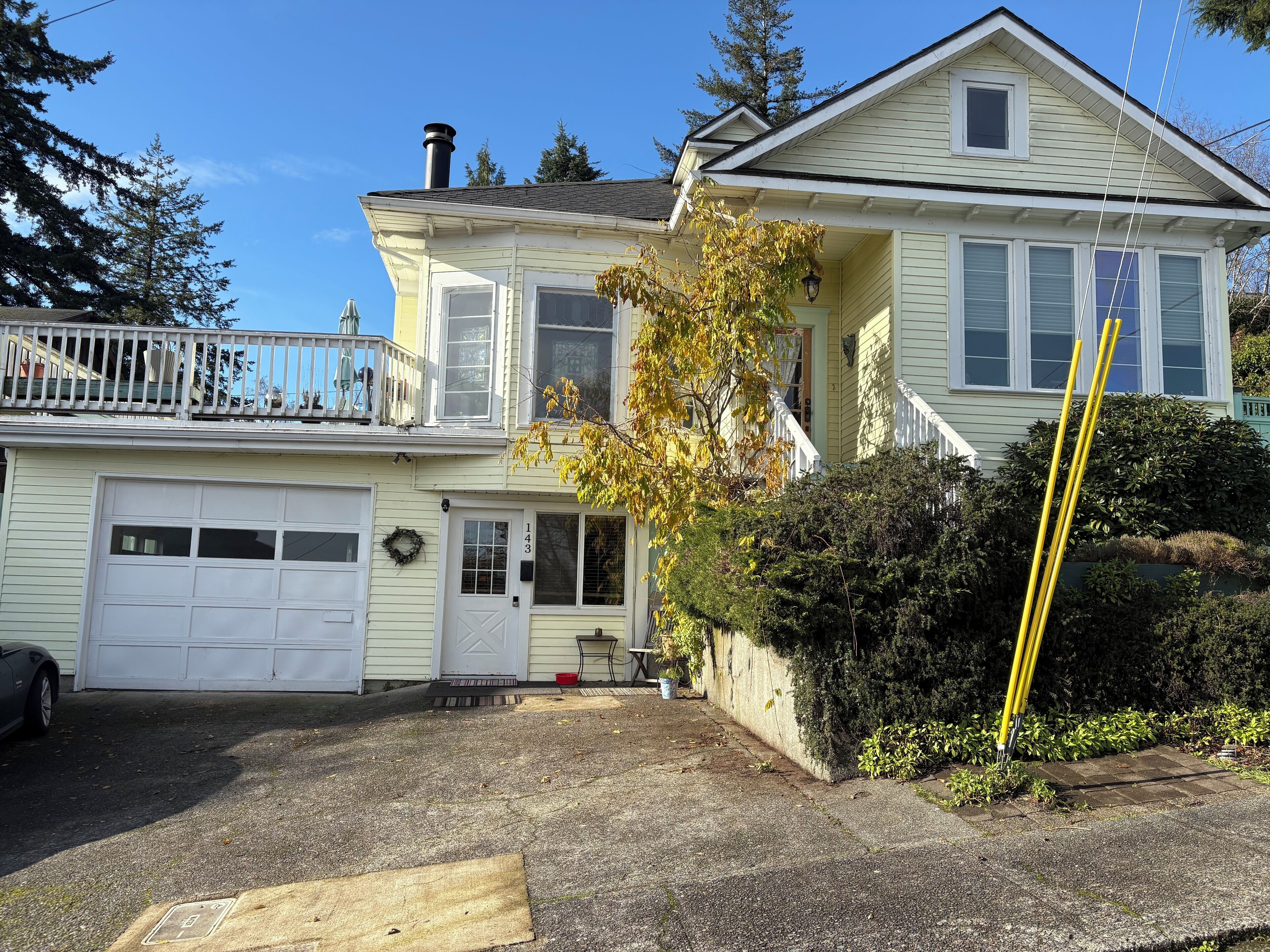 A two-story house with a garage, a front porch, and a balcony.