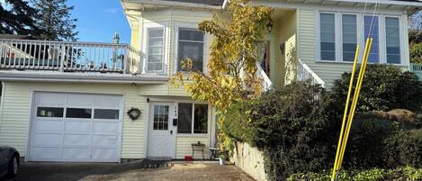 A two-story house with a garage, a front porch, and a staircase leading to the second floor.