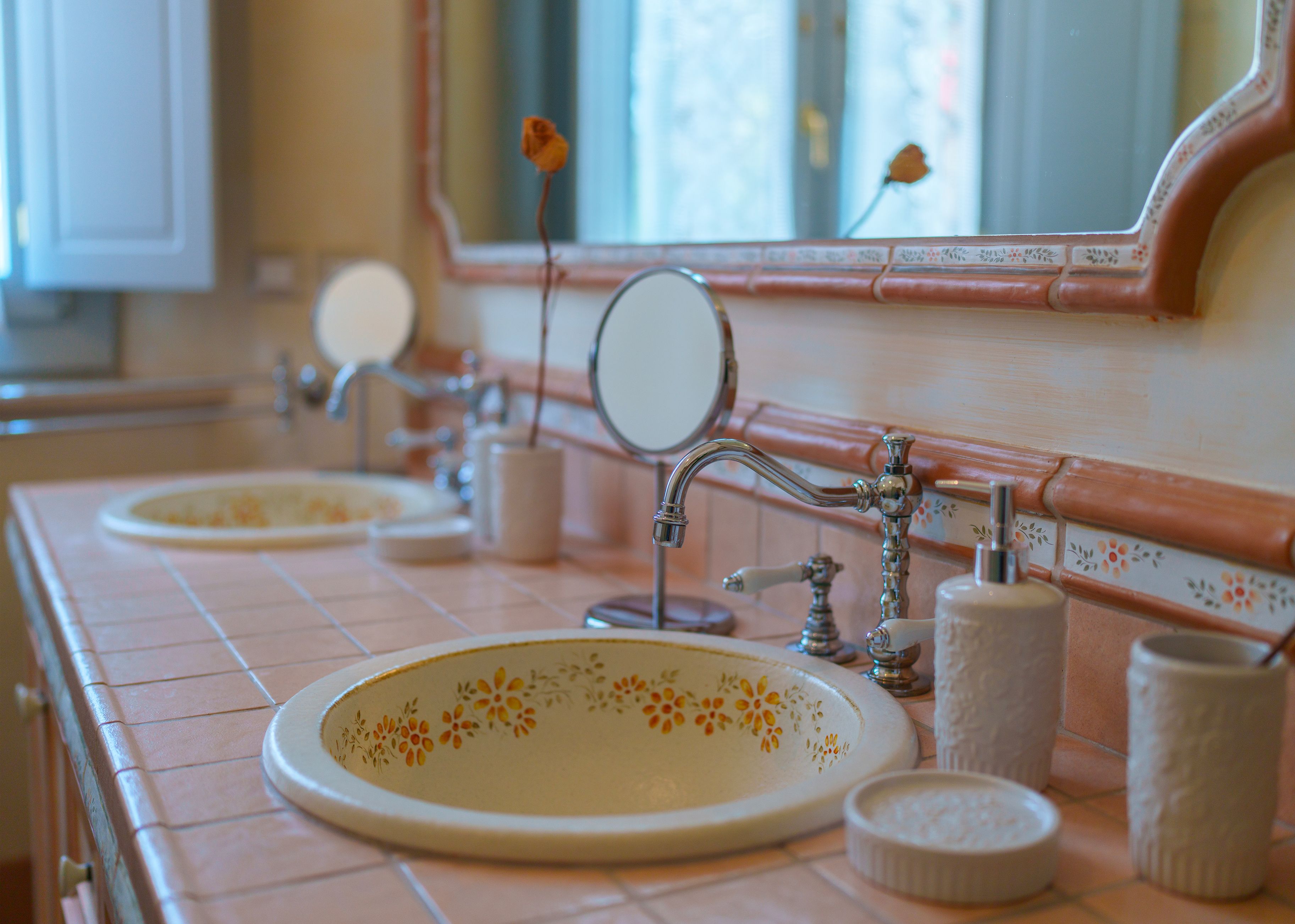 Un baño con dos lavamanos, cada uno con un espejo encima. Hay artículos de aseo en la encimera.