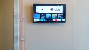 A flat-screen TV mounted on a wall displaying the Pommellato menu.